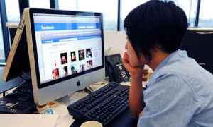 woman looking at Facebook in office