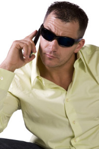 Isolated Man in trendy outfit with sunglasses talking on cell phone